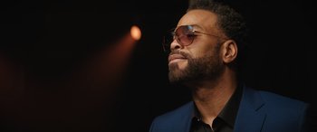 Movie still from “On the Come Up” (2022), directed by Sanaa Lathan – A person wearing a suit and sunglasses; Close Up shot, Low angle