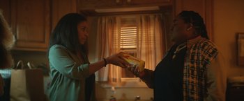 Movie still from “On the Come Up” (2022), directed by Sanaa Lathan – A woman is handing a box to another woman; Medium shot, Low angle