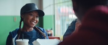 Movie still from “On the Come Up” (2022), directed by Sanaa Lathan – A woman sitting in front of a man holding a box; Close Up shot, Over the shoulder angle