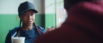 Movie still from “On the Come Up” (2022), directed by Sanaa Lathan – A young girl with a hat and braids looking at a man; Close Up shot, Over the shoulder angle