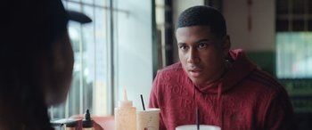 Movie still from “On the Come Up” (2022), directed by Sanaa Lathan – A man sitting at a table with a drink in front of him; Close Up shot, Over the shoulder angle