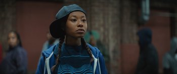 Movie still from “On the Come Up” (2022), directed by Sanaa Lathan – A young woman wearing a hat and a blue shirt; Close Up shot, Low angle
