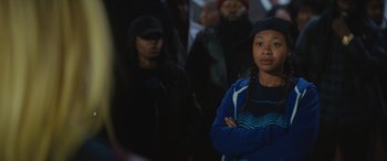 Movie still from “On the Come Up” (2022), directed by Sanaa Lathan – A group of people standing in a dark room; Medium shot, Over the shoulder angle