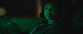 Movie still from “On the Come Up” (2022), directed by Sanaa Lathan – A person sitting on a couch in a dark room; Close Up shot, Over the shoulder angle