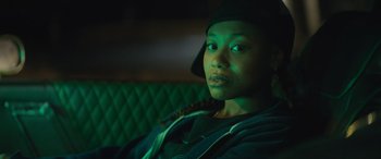 Movie still from “On the Come Up” (2022), directed by Sanaa Lathan – A woman sitting on a couch in a dark room; Close Up shot, Over the shoulder angle