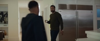 Movie still from “On the Come Up” (2022), directed by Sanaa Lathan – A man standing in front of another man in a room; Medium shot, Over the shoulder angle