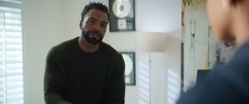 Movie still from “On the Come Up” (2022), directed by Sanaa Lathan – A man sitting in front of a wall with a microphone in the background; Close Up shot, Over the shoulder angle