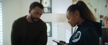 Movie still from “On the Come Up” (2022), directed by Sanaa Lathan – A man and a woman looking at each other while looking at a tablet; Medium shot, Over the shoulder angle