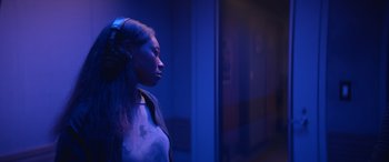 Movie still from “On the Come Up” (2022), directed by Sanaa Lathan – A woman with headphones standing next to a wall; Close Up shot, Over the shoulder angle