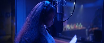 Movie still from “On the Come Up” (2022), directed by Sanaa Lathan – A woman with long black hair wearing headphones and a microphone; Close Up shot, Low angle