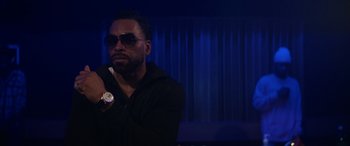 Movie still from “On the Come Up” (2022), directed by Sanaa Lathan – A man in a black jacket holding a watch; Close Up shot, Over the shoulder angle