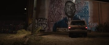 Movie still from “On the Come Up” (2022), directed by Sanaa Lathan – A car parked in front of a wall with graffiti; Medium shot, Low angle