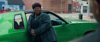 Movie still from “On the Come Up” (2022), directed by Sanaa Lathan – A woman standing in front of a green car; Medium shot, Low angle