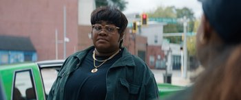 Movie still from “On the Come Up” (2022), directed by Sanaa Lathan – A woman wearing glasses standing on the side of the street; Close Up shot, Over the shoulder angle