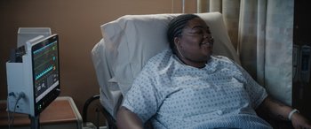 Movie still from “On the Come Up” (2022), directed by Sanaa Lathan – A woman laying in a hospital bed smiling; Medium shot, Over the shoulder angle