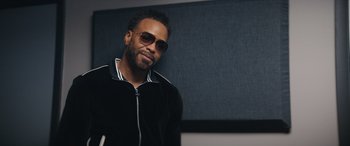 Movie still from “On the Come Up” (2022), directed by Sanaa Lathan – A person wearing sunglasses and a jacket; Close Up shot, Over the shoulder angle