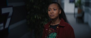 Movie still from “On the Come Up” (2022), directed by Sanaa Lathan – A young woman wearing a red jacket looking to her left; Close Up shot, Over the shoulder angle
