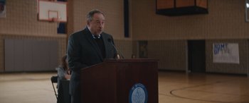Movie still from “On the Come Up” (2022), directed by Sanaa Lathan – A man standing at a podium speaking to a crowd; Medium shot, Over the shoulder angle