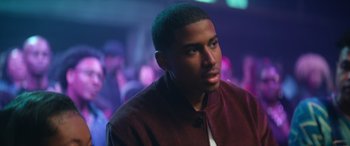 Movie still from “On the Come Up” (2022), directed by Sanaa Lathan – A man in a red jacket is in a room; Close Up shot, Over the shoulder angle