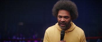 Movie still from “On the Come Up” (2022), directed by Sanaa Lathan – A man in a yellow jacket holding a microphone; Close Up shot, Low angle