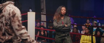 Movie still from “On the Come Up” (2022), directed by Sanaa Lathan – A woman standing in front of a crowd in a boxing ring; Medium shot, Over the shoulder angle
