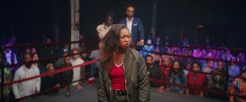 Movie still from “On the Come Up” (2022), directed by Sanaa Lathan – A woman standing in front of a group of people in a boxing ring; Medium shot, Over the shoulder angle