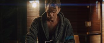 Movie still from “One Ranger” (2023), directed by Jesse V. Johnson – A man in a bathrobe is holding a coffee mug; Medium shot, Over the shoulder angle