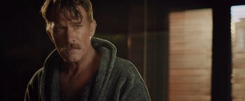 Movie still from “One Ranger” (2023), directed by Jesse V. Johnson – A person wearing a robe; Close Up shot, Over the shoulder angle