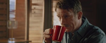 Movie still from “One Ranger” (2023), directed by Jesse V. Johnson – A person holding a cup of coffee; Close Up shot, Over the shoulder angle