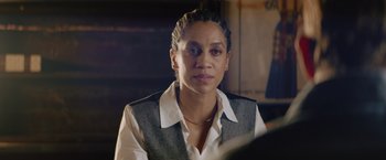 Movie still from “One Ranger” (2023), directed by Jesse V. Johnson – A woman in a white shirt and a gray vest; Close Up shot, Over the shoulder angle