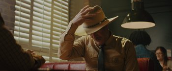 Movie still from “One Ranger” (2023), directed by Jesse V. Johnson – A man wearing a hat and a neck tie; Medium shot, Low angle