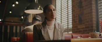 Movie still from “One Ranger” (2023), directed by Jesse V. Johnson – A woman sitting in front of a window in a restaurant; Medium shot, Over the shoulder angle