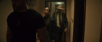 Movie still from “One Ranger” (2023), directed by Jesse V. Johnson – A man and a woman are walking down a hallway; Medium shot, Over the shoulder angle