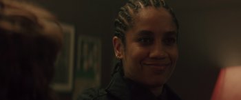 Movie still from “One Ranger” (2023), directed by Jesse V. Johnson – A person with a black shirt and some braids; Close Up shot, Over the shoulder angle