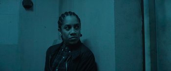 Movie still from “One Ranger” (2023), directed by Jesse V. Johnson – A man with dreadlocks is leaning against a wall; Close Up shot, Low angle