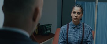 Movie still from “One Ranger” (2023), directed by Jesse V. Johnson – A man sitting in front of another man in an office; Close Up shot, Over the shoulder angle