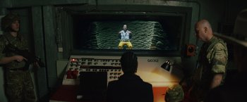 Movie still from “One Ranger” (2023), directed by Jesse V. Johnson – A person watching a man on a television screen; Wide shot, High angle