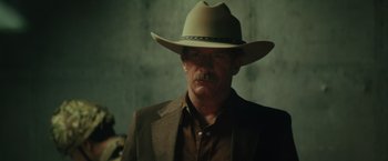 Movie still from “One Ranger” (2023), directed by Jesse V. Johnson – A man in a hat and a suit; Close Up shot, Low angle