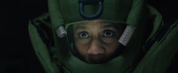 Movie still from “One Ranger” (2023), directed by Jesse V. Johnson – A person wearing a helmet and a green jacket; Close Up shot, High angle