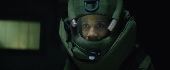 Movie still from “One Ranger” (2023), directed by Jesse V. Johnson – A man wearing a helmet and a green jacket; Close Up shot, Low angle