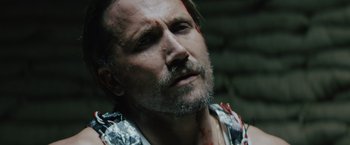 Movie still from “One Ranger” (2023), directed by Jesse V. Johnson – A person wearing a shirt with blood all over it; Close Up shot, High angle