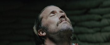 Movie still from “One Ranger” (2023), directed by Jesse V. Johnson – A person with his eyes closed; Close Up shot, Low angle