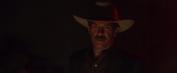 Movie still from “One Ranger” (2023), directed by Jesse V. Johnson – A man wearing a cowboy hat in the dark; Close Up shot, Low angle