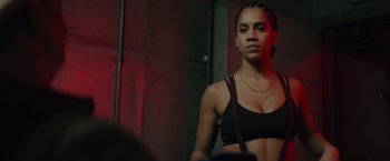 Movie still from “One Ranger” (2023), directed by Jesse V. Johnson – A woman in a black top is standing in a room; Close Up shot, Low angle