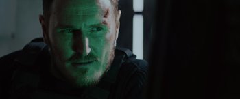 Movie still from “One Ranger” (2023), directed by Jesse V. Johnson – A person with a face covered in green paint; Close Up shot, Over the shoulder angle