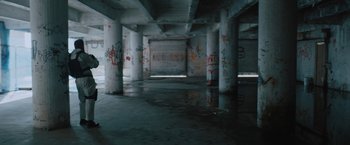Movie still from “One Ranger” (2023), directed by Jesse V. Johnson – A view of a building with graffiti on the walls; Extreme Wide shot, High angle