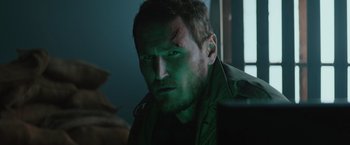 Movie still from “One Ranger” (2023), directed by Jesse V. Johnson – A person wearing a green shirt; Close Up shot, Over the shoulder angle