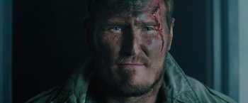 Movie still from “One Ranger” (2023), directed by Jesse V. Johnson – A person with a wound on his face; Close Up shot, Low angle