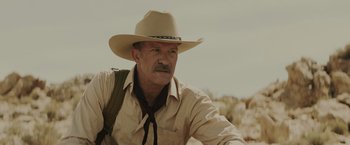 Movie still from “One Ranger” (2023), directed by Jesse V. Johnson – An older man wearing a cowboy hat and a neck tie; Close Up shot, Low angle