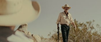 Movie still from “One Ranger” (2023), directed by Jesse V. Johnson – A man in a cowboy hat holding a gun; Medium shot, Low angle